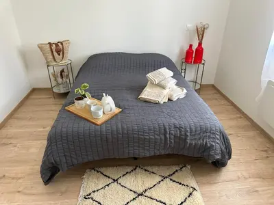 a bed with a gray blanket and a tray with pillows at La Maison Belle Étoile in Limoux