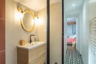 a bathroom with a sink and a mirror at La Bastide - Terrasse - Jacuzzi in Carcassonne