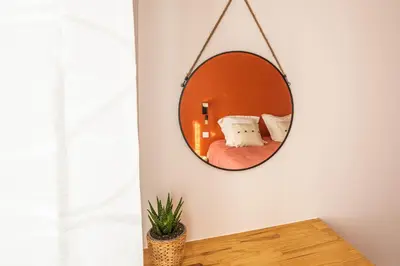 a mirror hanging on a wall in a room at La Bastide - Terrasse - Jacuzzi in Carcassonne