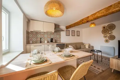 a kitchen and living room with a table and chairs at La Bastide - Terrasse - Jacuzzi in Carcassonne