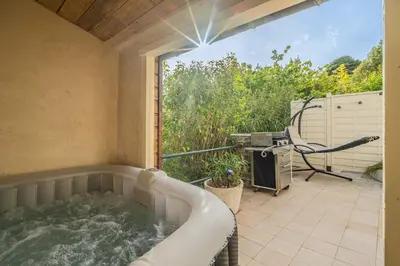 a hot tub on a patio with a grill at La Bastide - Terrasse - Jacuzzi in Carcassonne