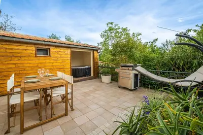 a patio with a table and a stove at La Bastide - Terrasse - Jacuzzi in Carcassonne