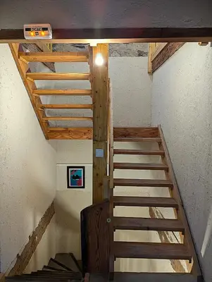 a staircase in a room with a wooden ceiling at CROUXETO Chambres d'hôte in Duilhac