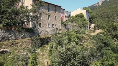 an old building on the side of a mountain at CROUXETO Chambres d'hôte in Duilhac