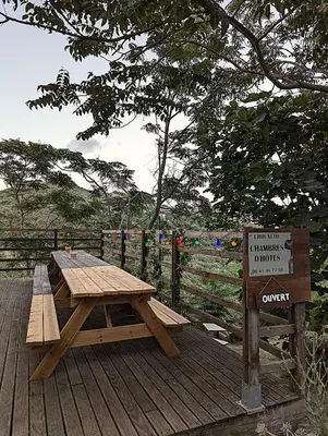 a wooden picnic table on a wooden deck with a sign at CROUXETO Chambres d'hôte in Duilhac