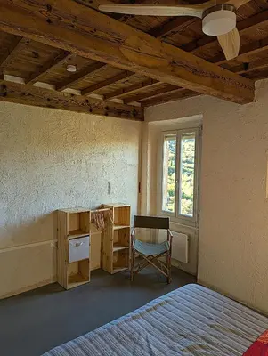 a bedroom with a bed and a desk and a chair at CROUXETO Chambres d'hôte in Duilhac