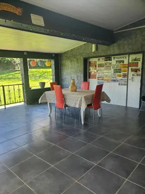 a dining room with a table and red chairs at Villa privée au calme avec gand jardin et terrasse in Bout-du-Pont-de-Larn