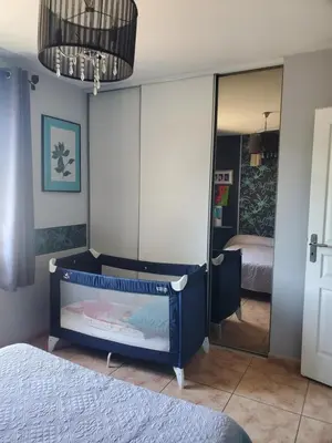 a bedroom with a crib and a mirror at Villa privée au calme avec gand jardin et terrasse in Bout-du-Pont-de-Larn