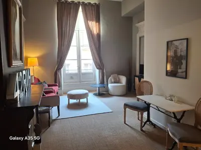 a living room with a table and chairs and a window at The Cozy 42 stylish apartment in Carcassonne
