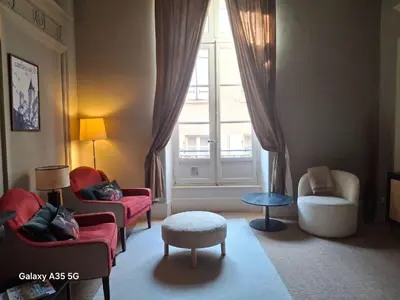 a living room with two chairs and a window at The Cozy 42 stylish apartment in Carcassonne