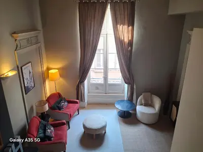 a living room with chairs and a large window at The Cozy 42 stylish apartment in Carcassonne