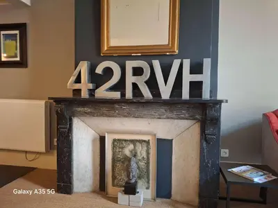 a fireplace in a living room with a clock above it at The Cozy 42 stylish apartment in Carcassonne