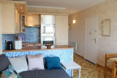 a living room with a couch and a kitchen at Port la Nouvelle - Appartement 3 pièces PN550-023 in Port-la-Nouvelle