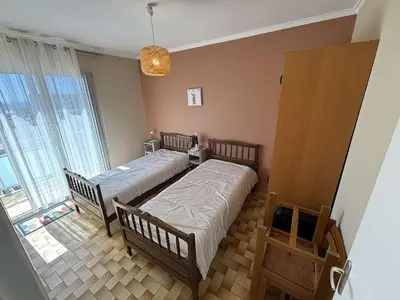a bedroom with two beds and a large window at Port la Nouvelle - Appartement 3 pièces PN550-023 in Port-la-Nouvelle
