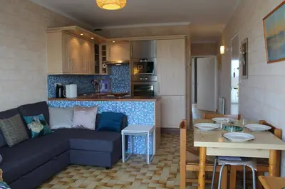 a living room and kitchen with a couch and a table at Port la Nouvelle - Appartement 3 pièces PN550-023 in Port-la-Nouvelle