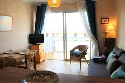 a living room with a couch and a table and a window at Port la Nouvelle - Appartement 3 pièces PN550-023 in Port-la-Nouvelle