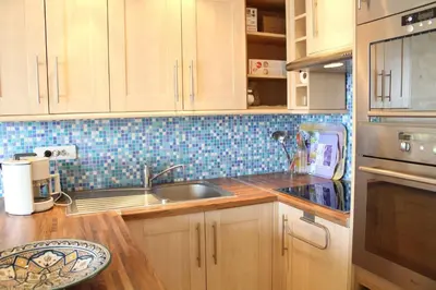 a kitchen with wooden cabinets and a sink at Port la Nouvelle - Appartement 3 pièces PN550-023 in Port-la-Nouvelle