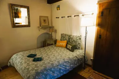 a small bedroom with a bed and a mirror at Albizia in La Redorte
