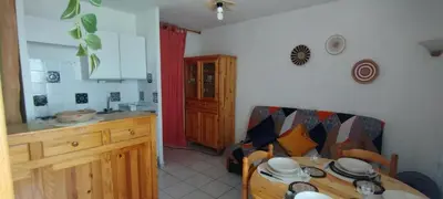 a kitchen with a table and a dining room at Apt de charme 4 pers, vue port, location idéale in Gruissan