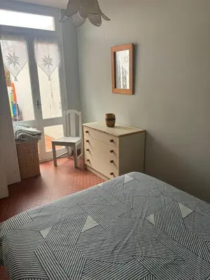 a bedroom with a bed and a dresser and a window at Pavillon cosy 6 pers Patio privé et plage à pied in Port-la-Nouvelle