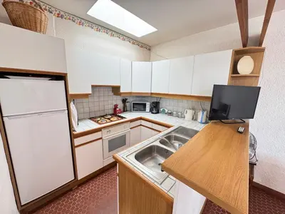 a kitchen with a sink and a white refrigerator at Pavillon cosy 6 pers Patio privé et plage à pied in Port-la-Nouvelle