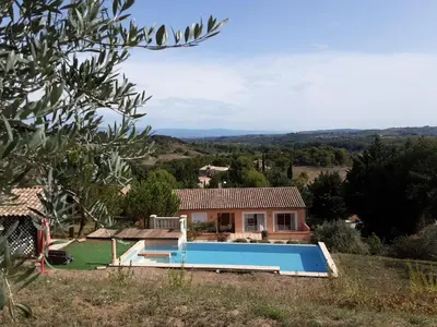 a house with a swimming pool in front of it at Chez Hélène et Michel in Preixan