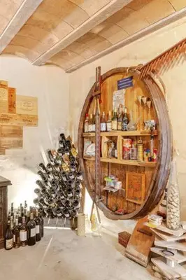 a room with a bunch of wine bottles on a wall at Chez Hélène et Michel in Preixan