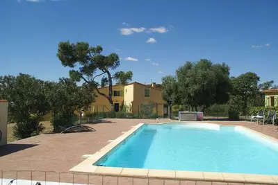 a swimming pool in front of a house with trees at Domaine Saint Antoine in Rieux-Minervois