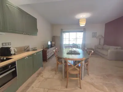 a kitchen with a table and chairs and a living room at la redorte 25 in La Redorte