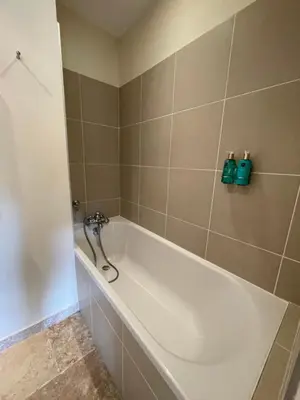 a bath tub in a bathroom with green tiles at La Redorte 28 in La Redorte