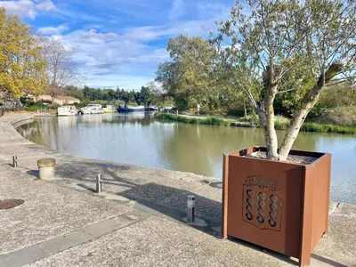 a tree in a box next to a river at La Redorte 28 in La Redorte