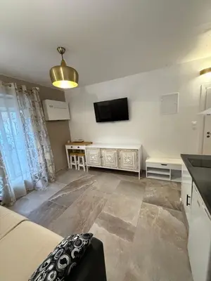 a living room with a bed and a flat screen tv at studio centre ville in Narbonne