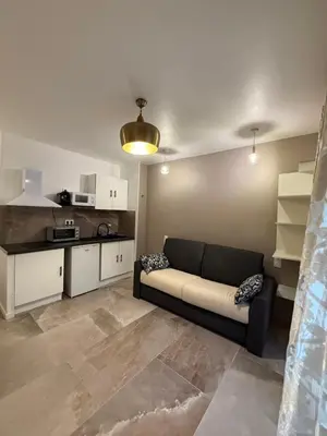 a living room with a couch and a kitchen at studio centre ville in Narbonne