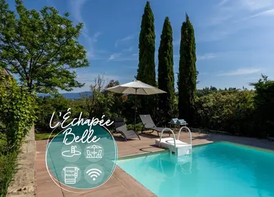 a villa with a swimming pool and an umbrella at L'Échappée Belle - Grande Maison, Jardin & Piscine in Castres