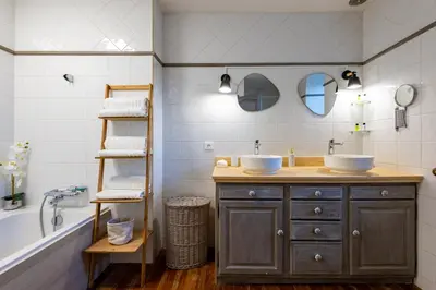 a bathroom with a wooden vanity with two sinks and a tub at L'Échappée Belle - Grande Maison, Jardin & Piscine in Castres