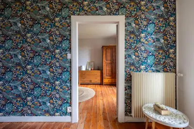 a room with a wall with a blue floral wallpaper at L'Échappée Belle - Grande Maison, Jardin & Piscine in Castres