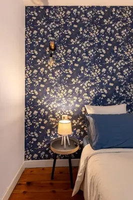 a bedroom with a blue floral patterned wall at L'Échappée Belle - Grande Maison, Jardin & Piscine in Castres