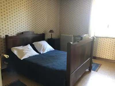 a bedroom with a bed with blue sheets and white pillows at maison des Géraniums in Trausse