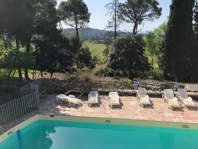 a group of lounge chairs and a swimming pool at maison des Géraniums in Trausse