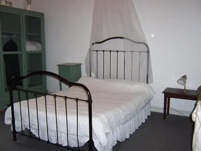 a bedroom with a bed with white sheets and a window at maison des Géraniums in Trausse