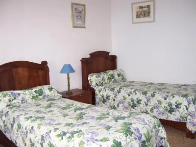 a bedroom with two beds and a table with a lamp at maison des Géraniums in Trausse