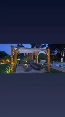 a gazebo with lights on it next to a pool at Le nid du canal in Pezens