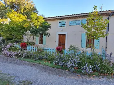 a house with a bunch of flowers in front of it at Le nid du canal in Pezens