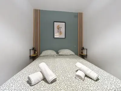 a bedroom with a large bed with two pillows at Le BEHNA - Wi-Fi Apartment - Air Conditioning in Narbonne