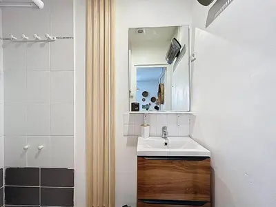a bathroom with a sink and a mirror at Le BEHNA - Wi-Fi Apartment - Air Conditioning in Narbonne