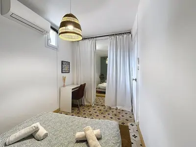 a bedroom with a bed with two towels on it at Le BEHNA - Wi-Fi Apartment - Air Conditioning in Narbonne