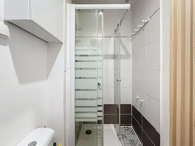 a glass shower in a bathroom with a toilet at Le BEHNA - Wi-Fi Apartment - Air Conditioning in Narbonne