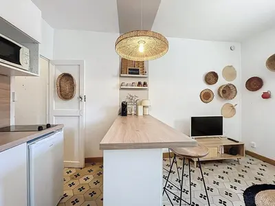 a kitchen with a counter and a table in a room at Le BEHNA - Wi-Fi Apartment - Air Conditioning in Narbonne