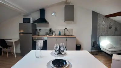 a kitchen with a table with two wine glasses on it at COSY APPARTEMENT INDEPENDANT I 2 LITS l 1 CHAMBRE I 2 TV I Netflix l Terrasse in Castres