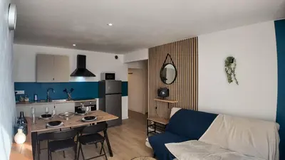 a kitchen and a living room with a couch and a table at Elégant Appartement - 2 Chambres - Netflix - Terrasse in Castres